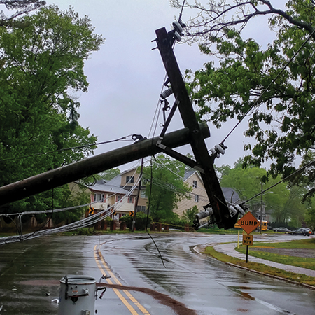 Telephone pole fallen over a road.