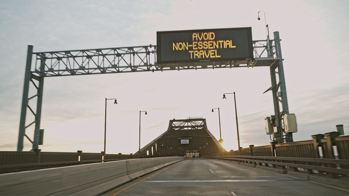 Pulaski Skyway with digital sign saying: 'Avoid Non-Essential Travel'.